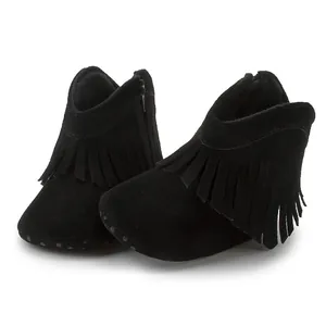 Macro detail of baby tassel boots showing soft suede texture and side zipper