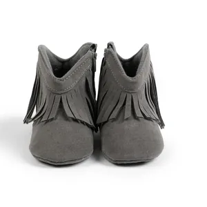 Detail view of baby suede boots featuring side zipper and decorative fringe trim