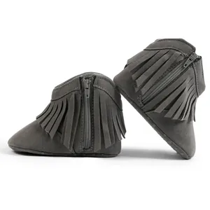 Close-up of grey baby fringe boots showing metal zipper and anti-slip rubber sole dots