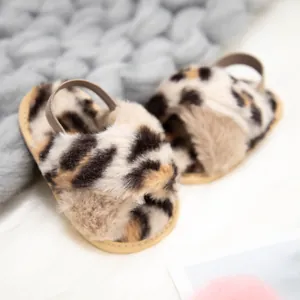 Gros plan détaillé de chaussons en peluche léopard pour bébé avec bride arrière élastique