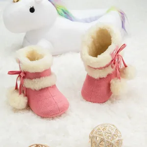 Gros plan de bottes neige roses bébé avec doublure en peluche blanche et pompons