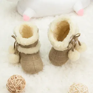 Détail de bottes de neige bébé avec doublure en fausse fourrure et nœud à pompon en peluche