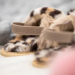 Gros plan détaillé de chaussons en peluche léopard pour bébé avec bride élastique