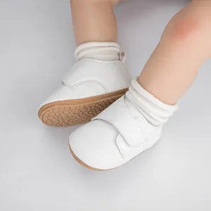 Gros plan de chaussures bébé en cuir blanc avec semelles antidérapantes et velcro