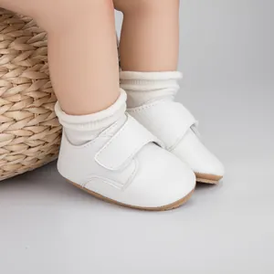 Détail de chaussures de marche bébé en cuir blanc avec velcro et semelle antidérapante