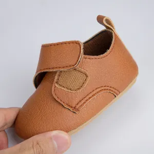 Gros plan de chaussures bébé en cuir PU marron avec fermeture velcro et semelle souple