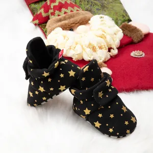 Chaussures de marche bébé noires à étoiles dorées sur fond de fausse fourrure blanche