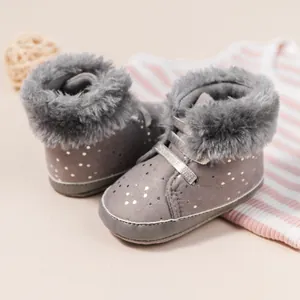 Dettaglio stivaletti neonato grigi con fodera in peluche e pois argento e suola morbida