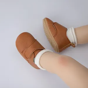 Gros plan de chaussures de bébé en similicuir marron avec semelles antidérapantes