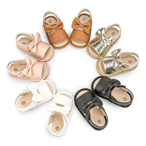 Overhead view showing five pairs of bow-knot baby sandals in brown pink gold white and black