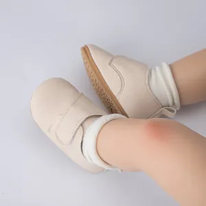 Détail de chaussures bébé beiges avec semelles antidérapantes et attaches velcro