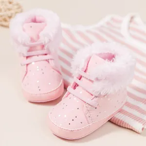 Dettaglio di scarpine primi passi rosa con paillettes argento e fodera in pelliccia bianca