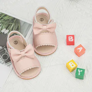 Detailed macro view of pink baby sandals with large bow and soft textured inner sole