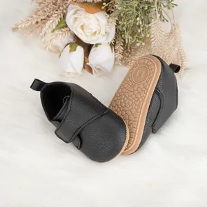 Détail d'une chaussure bébé avec cuir noir grainé et semelle en caoutchouc antidérapant