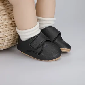 Détail latéral des chaussures bébé en similicuir noir avec attache velcro et semelle souple