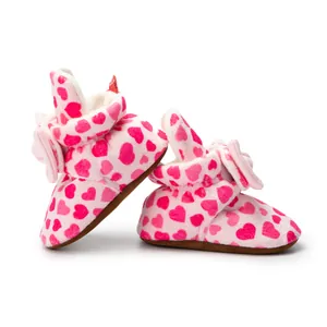 Détail de chaussures de marche pour bébé avec semelles antidérapantes et motifs cœurs