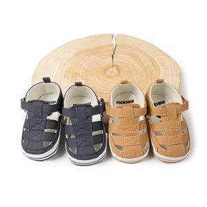 Détail de sandales bébé respirantes en bleu marine et kaki sur socle en bois naturel