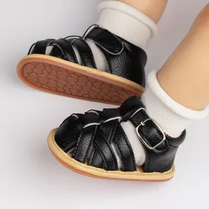 Macro view of black leather baby sandals with woven straps and anti-slip rubber soles