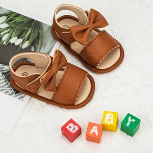 Brown infant summer sandals with decorative bow and breathable scalloped leather design
