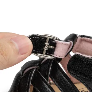 Detail of baby leather sandal featuring adjustable hook-and-loop strap and silver buckle
