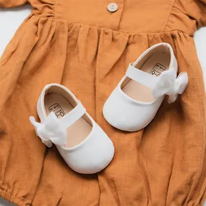 Dettaglio di scarpe Mary Jane bianche per neonato con fiocco in tulle e soletta