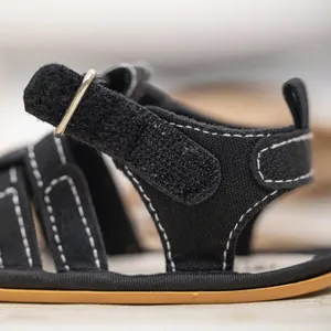 Detail of baby canvas sandals with velcro straps, stitching, and brown sole textures
