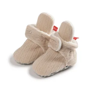 Details beige gestrickter Babyschuhe mit warmem Fleecefutter und Druckknöpfen