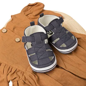 Sandales bébé bleu marine et robe jaune à volants sur un plateau en bois rustique