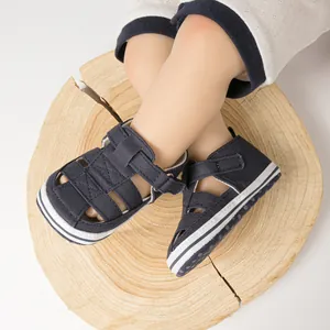 Détail de sandales bébé bleu marine avec design ajouré respirant et semelle souple antidérapante