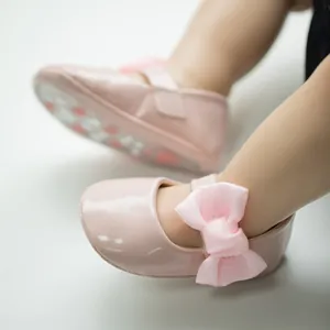 Dettaglio scarpe neonata Mary Jane in vernice rosa con fiocco in raso e cinturino