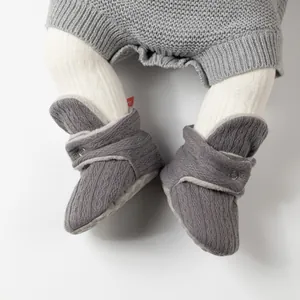 Detail von dunkelgrauen Baby-Strickschuhen mit gemütlichem weißem Lammfell-Innenfutter