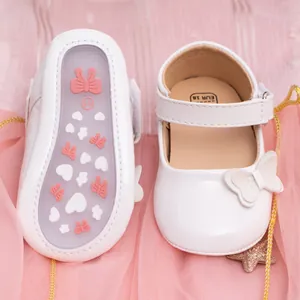 Detailed view of white PU baby shoes with non-slip heart patterns and bow decor