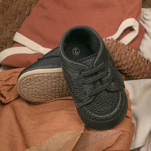 Detail of baby walking shoes with black textured leather and anti-slip rubber soles
