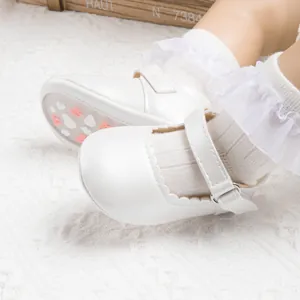 White Mary Jane baby shoes with scalloped edges and non-slip soles for toddlers