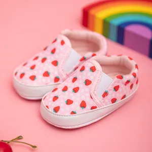 Close-up of pink canvas baby shoes with strawberry patterns and white soft soles