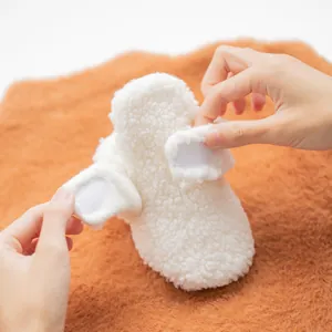 Plush white baby walker shoes with warm fleece material and Velcro strap closure