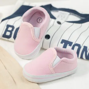 Close-up of pink baby canvas loafer with striped lining and soft rubber toe guard