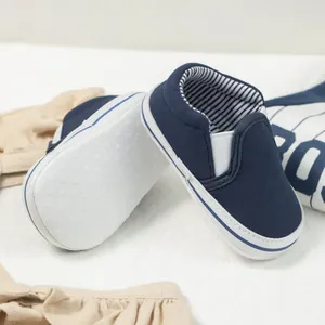 Close-up of navy canvas baby loafers with non-slip soft soles and blue striped lining