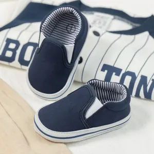 Close-up of navy canvas baby loafer with soft sole and striped cotton lining detail