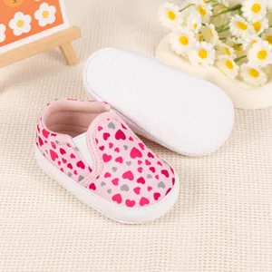 Detail of pink heart-patterned baby loafers showing non-slip sole and elastic strap