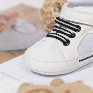 Detailed close-up of white baby walker shoes with stitching and elastic laces