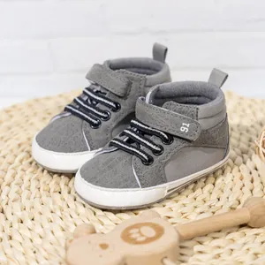 Detail of grey high-top baby shoes with velcro strap and non-slip white soles