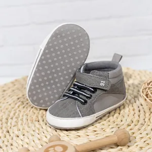 Detail showing non-slip dotted sole and gray PU leather finish of infant baby shoes