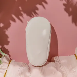 Détail de la semelle souple beige pour bébé princesse avec couture fine sur fond rose