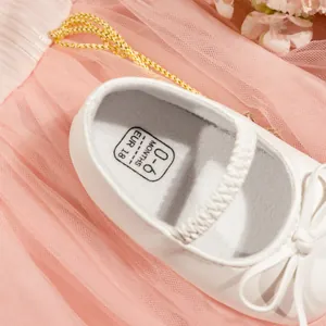 Vue détaillée de chaussures de princesse bébé blanches avec nœud et sangle élastique