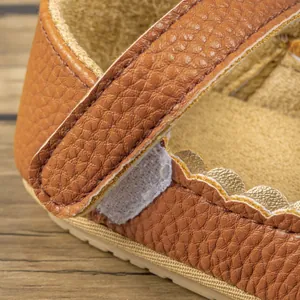 Makrodetail eines braunen Babylederschuhs mit Klettverschluss und Lychee-Narbung