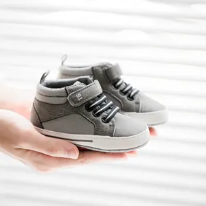 Detail of grey baby high-top walker shoes with hook-and-loop strap and soft anti-slip sole