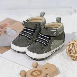 Detail of army green baby walking shoes with hook-and-loop straps and non-slip soft soles