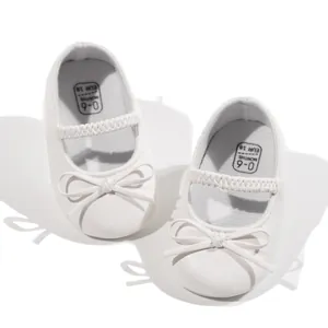 Chaussures princesse blanches pour bébé avec nœud et bande élastique sur fond d'ombre papillon