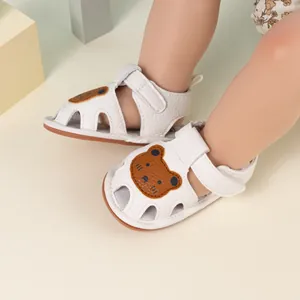 Close-up of white baby sandals with cartoon bear head and breathable hollow-out design